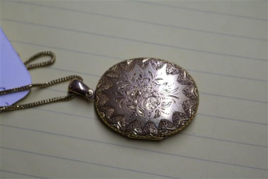 A Victorian engraved yellow metal oval locket, on a 9ct gold chain, locket 37mm.